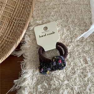 Detail of handmade colorful pompom hair ties set with ribbed elastic bands and card