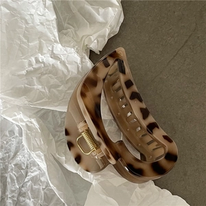 Detail of elegant large hair claw clip featuring classic tortoiseshell pattern and gold spring