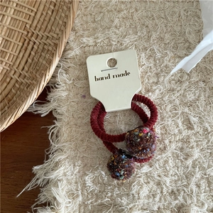 Close-up of handmade colorful yarn ball hair ties on a card for girls and children