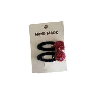 Cute colorful pom pom hair clips set for girls featuring red plush balls on black clips