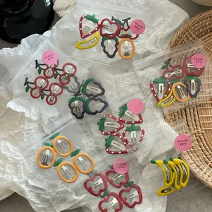 Close-up of cute fruit-shaped hair clips including strawberry and banana in frosted bags