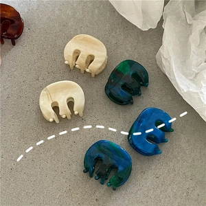 Close-up of marble textured acetate mini hair claws in various elegant colors