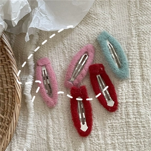 Close-up of five colorful plush teardrop snap clips for women in soft autumn fabrics