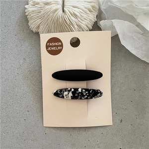 Détail de pinces à cheveux BB à fleurs et noir mat sur carte de bijoux de mode
