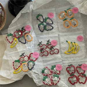 Close-up of cute colorful fruit hair clips in small gift bags with thank you stickers