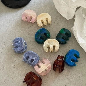 Flat lay of colorful acetate hair claws with marble textures and smooth curved teeth design