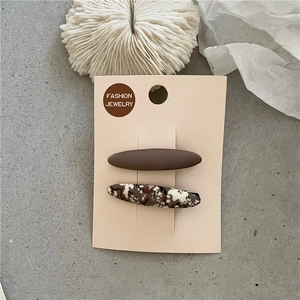 Détails de pinces à cheveux à fleurs et marron mat sur carte de présentation texturée