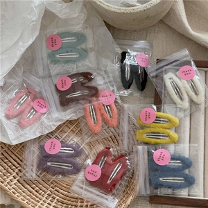 Set of ten colorful plush teardrop hair clips in cream tones with elegant packaging