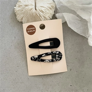 Gros plan de barrettes à cheveux à fleurs sur carte de présentation en carton beige