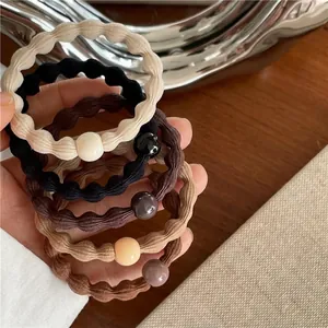 Set di cinque elastici per capelli ondulati in toni della terra con perle coordinate
