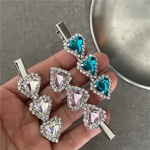 Three crystal heart hair clips in white, pink, and teal with silver rhinestone edges