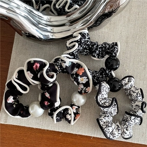 Floral fabric scrunchies with wavy edges and decorative pearl beads in a 3-piece set