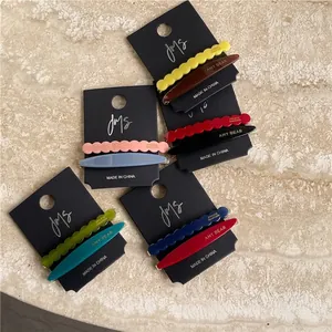 Minimalist geometric acetate hair clips set in various colors on a marble background