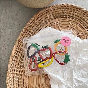 Close-up of colorful fruit shaped hair clips in a transparent thank you gift bag