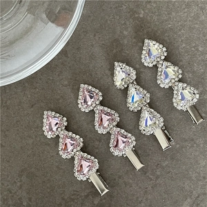 Detail showing crystal heart hair clips with sparkling rhinestones in pink and white