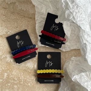 Close-up of geometric acetate hair clip sets on display card with metal backing