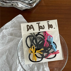 Detailaufnahme bunter Schleifen-Haargummis mit elastischen Bändern in Klarsichtverpackung