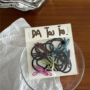 Detailaufnahme verschiedener bunter Samtschleifen-Haargummis in Klarsichtverpackung