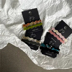 Geometrical wavy acetate hair clips in multiple colors on branded display cards