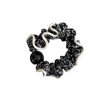 Floral fabric scrunchie with black and white print, white piping and large black bead