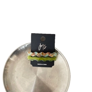 Brown marble and translucent green wavy acetate hair clips set on a silver tray