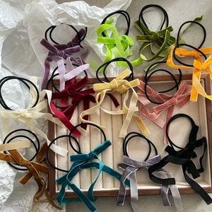 Detailed macro view of colorful velvet bow hair ties with elegant long ribbons