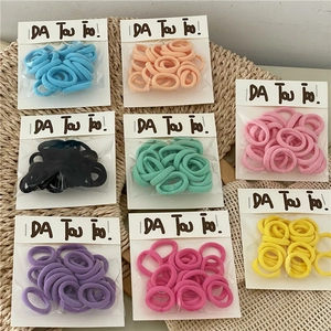 Close-up of colorful elastic towel hair ties for kids in various soft cream-colored pastel shades