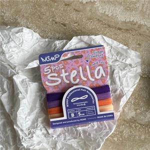 Detailed view of five high-elasticity hair ties in cream tones on a marble surface