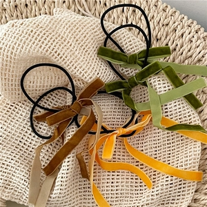 Close-up of vintage velvet bow hair ties in dark green, yellow and brown colors
