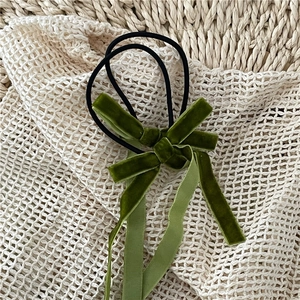 Detail of dark green velvet bow hair tie with long ribbons and high-elastic rubber band