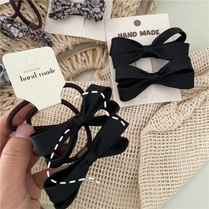 Detail of handmade floral and black satin bow hair ties and clips on display cards