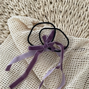 Detail of two purple velvet long bow hair ties with elastic bands for ponytails