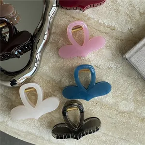 Detailed view of colorful heart-shaped resin hair claws on a textured stone surface