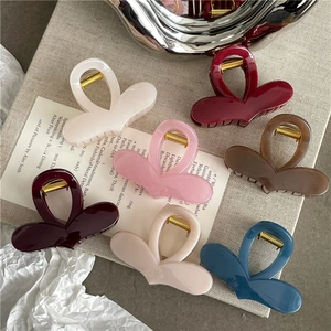 Close-up of heart-shaped hair claw clips in six jelly colors with glossy finish