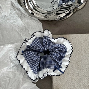 Detailed texture of blue plaid scrunchie with lace trim and elegant navy ribbon bow