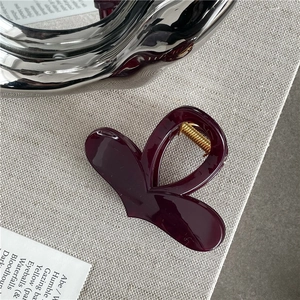 Close-up of deep red heart hair claw clip with glossy finish and gold metal spring