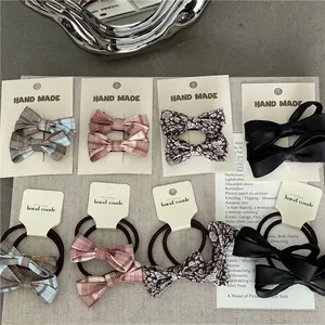 Detail view of handmade plaid and floral bow hair ties and clips on linen background