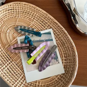 Dettagli di fermagli per capelli colorati con texture a onde su un vassoio intrecciato