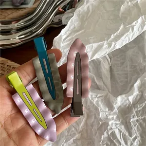 Tre fermagli per capelli ondulati in metallo bicolore con finitura in smalto lucido