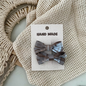 Detail of blue and brown checkered bow hair clips on hand made display card