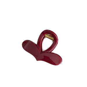 Glossy deep red heart-shaped hair claw clip made of acrylic with golden spring