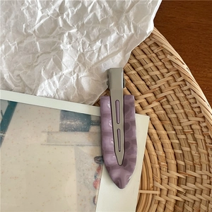 Dettaglio della molletta per capelli in resina viola marmorizzata e base in metallo