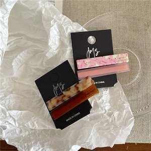 Detailed view of colorful acetate geometric hair clips on elegant display cards