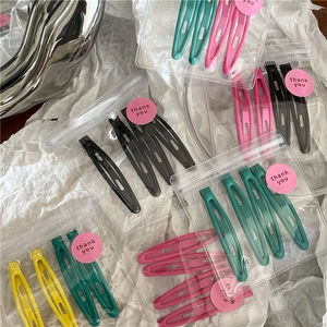 Macro detail of colorful metal snap hair clips in transparent thank you gift packaging