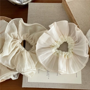 Détails du tissu en maille beige sur des chouchous élégants de grande taille
