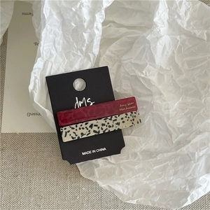Close-up of rectangle acetate hair clips in wine red and classic leopard print patterns