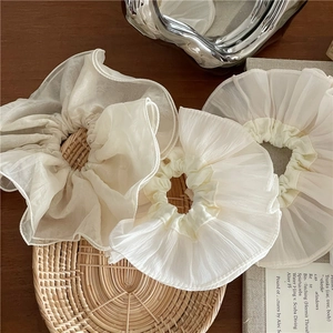 Lot de trois chouchous géants en organza ivoire dans un décor lifestyle élégant