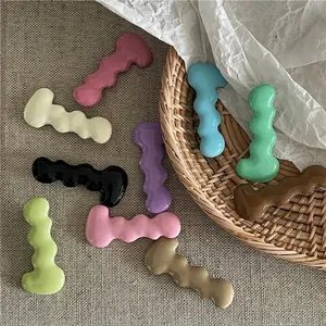 Set of colorful wave-shaped caterpillar hair clips in various pastel resin finishes