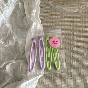 Pastel lavender and green matte metal hair clips in clear 'thank you' packaging