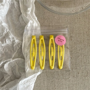 Set of four yellow metal hair clips neatly organized in a transparent frosted zipper bag